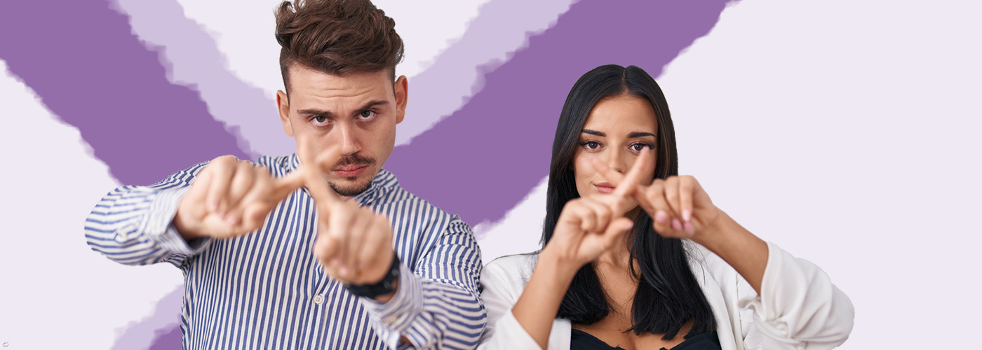 2 Menschen vor lila Wahlkreuz die mit dem Finger Kreuze zeigen